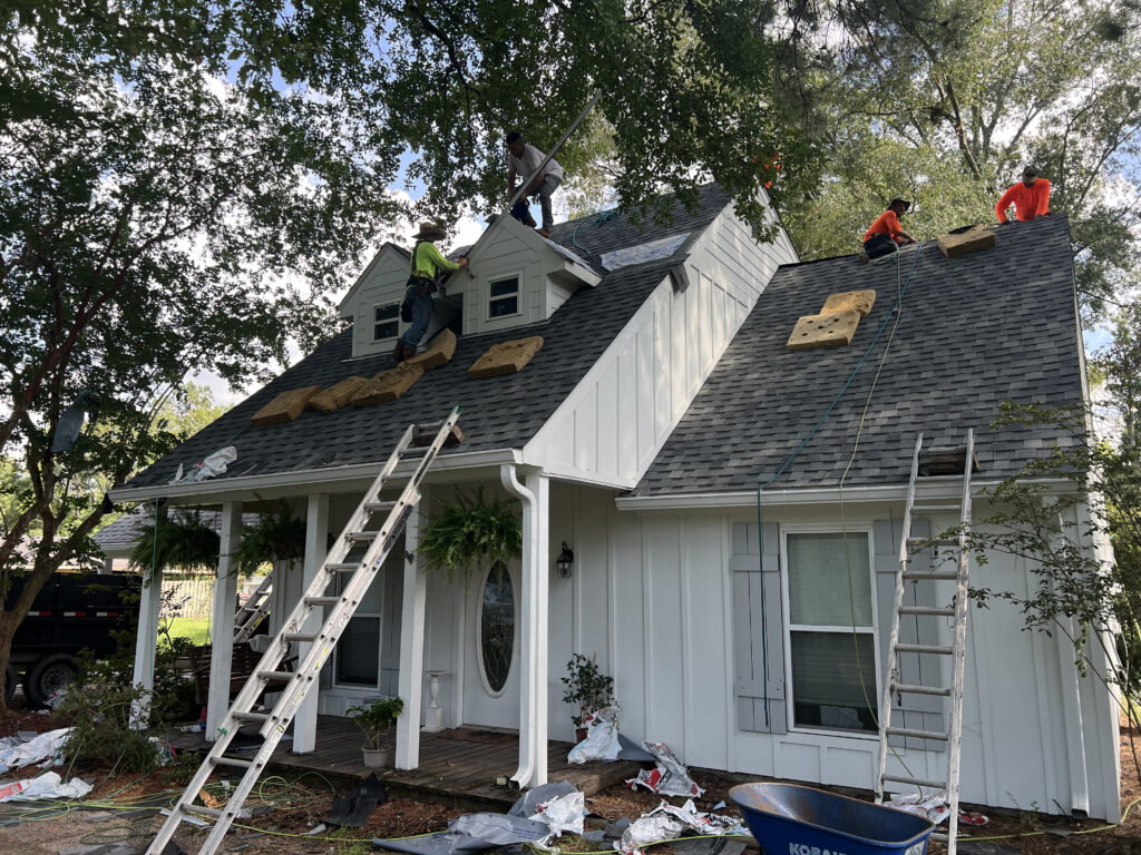 Roofing crew working on a white house