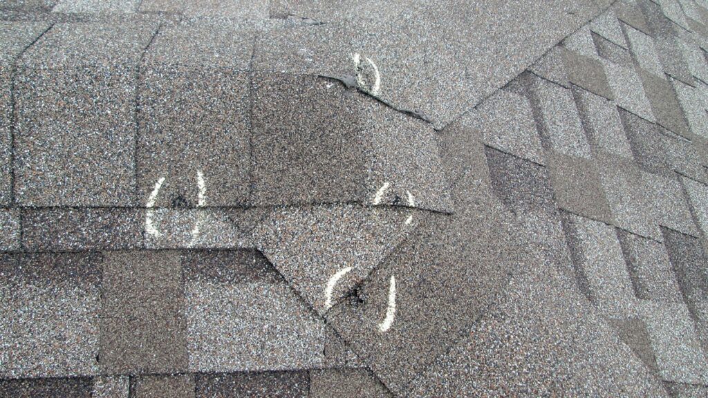Damaged shingles marked for roof repair